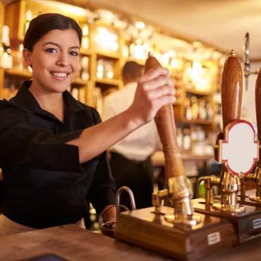 Woman pouring a pint at a pub